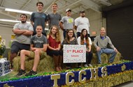 Heaven-Leigh Ferguson, Riley Jones, Tyler Williamson, Langley Wooten, and Caleb Clark decorate the float during Thanksgiving break.  TCCHS students pose with their float and first place plaque.