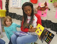  Hand-In-Hand Primary School kindergartner Emily Sparks listens to TCCHS ECE student Areana Cason read a story.
