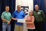 Dan May, Jimmy Moore and Lee Waller accept a donation check from TCCHS Chick-fil-A Leader Academy member and fundraising chairperson Danielle Sauls.