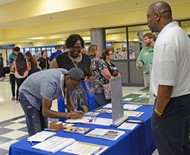 TCCHS English teacher Renae Moore and senior James Jones interact with a college representative to obtain more information about Albany State University.