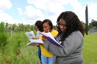  Students Briona Walker, Malaysia Walker and Adryanah Watson record observed insects.