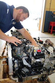 Instructor Michael Clapper is happy to receive this donated 6.4L diesel engine.