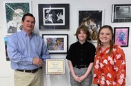 TCCHS sophomore Addison Weiss receives her first-place award from Rep. Austin Scott with her art teacher, Maria Pittman.