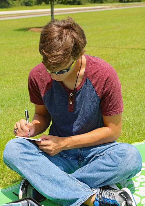 Student reporter John Maichele writes down his observations during the solar eclipse.