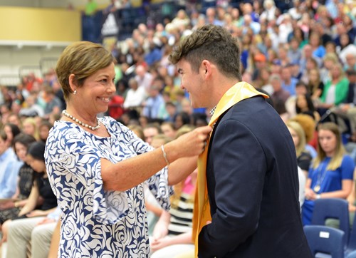 enior Tyler Carter and Principal Trista Jones share a smile after she placed his honor graduate stole around his shoulders.