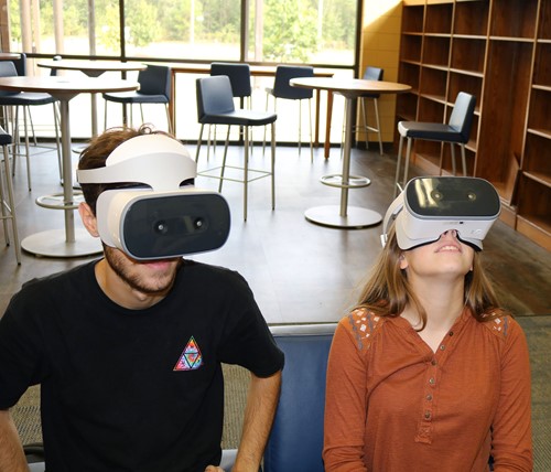 Earth Systems students Logan Poppell and Brianna Beamon react to what they see through their virtual reality goggles.